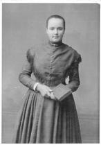 SA0111 - 3/4 length studio portrait of unidentified Shaker woman shown holding a book.